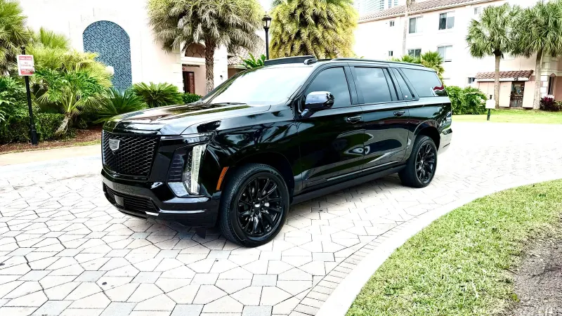 Black Cadillac Escalade SUV in a driveway